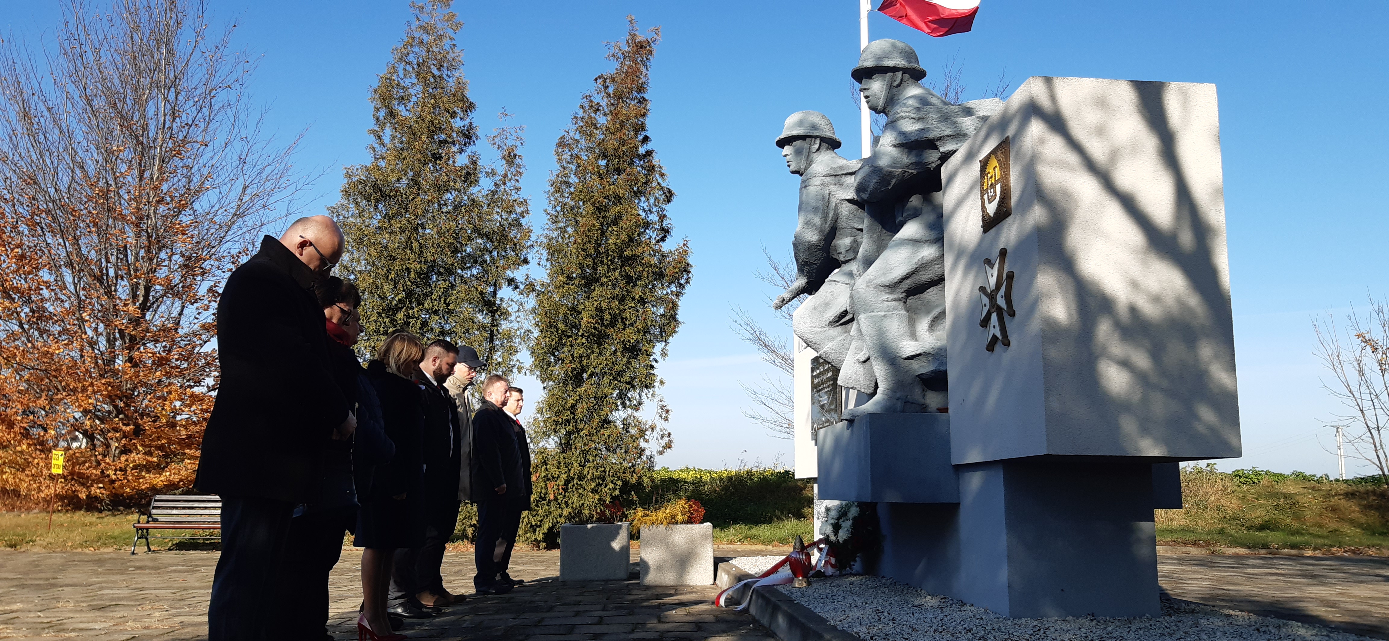 delegacja urzędu miesjkiego i rady miejskiej składa kwiaty pod pomnikiem
