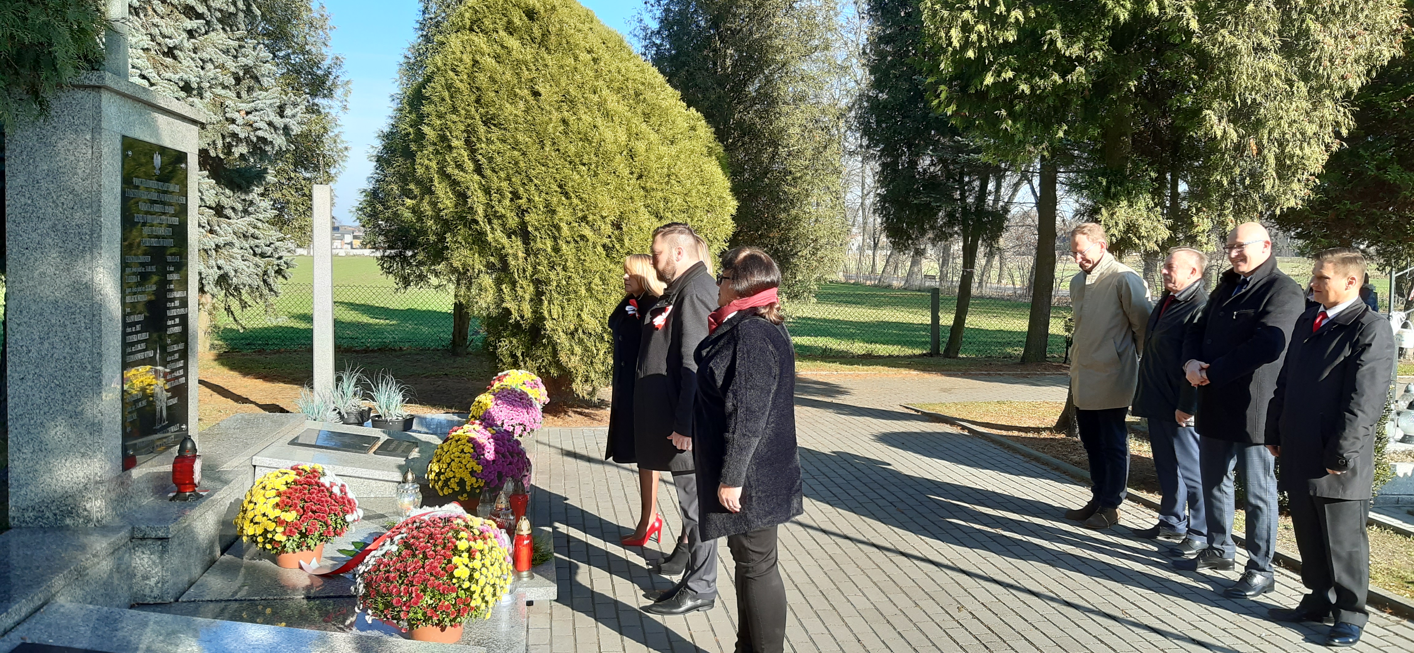 delegacja urzędu miesjkiego i rady miejskiej składa kwiaty na cmentarzu