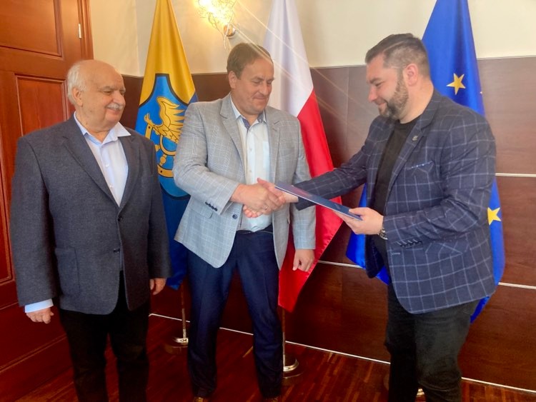 radny Andrzej Staron, Piotr Hucz spółka Hucz, Michał Aloszko burmistrz Woźnik na tle flag Unii Polski i Woźnik