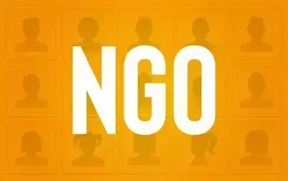 pomarańczowa plansza na niej biały napis wielkie litery NGO