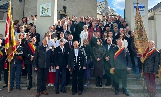 na schodach przed kościołem ustawiona grupa rzemieślników, z przodu poczty sztandarowe